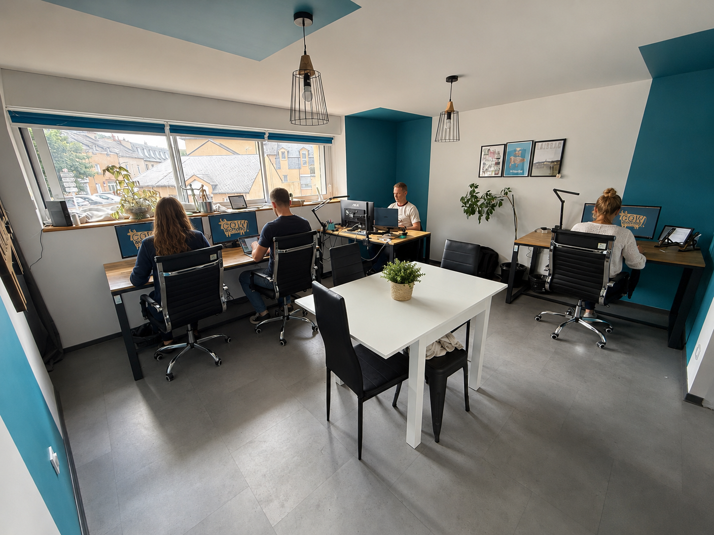 Espace de bureau partagé lumineux avec plusieurs postes face à une grande baie vitrée